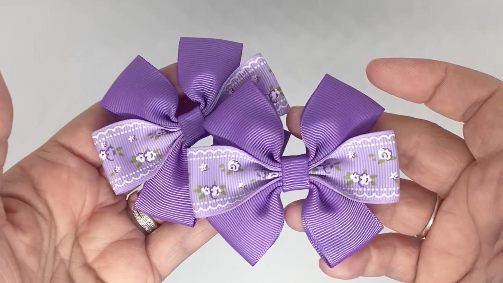 Close-up of lilac floral hair bows on alligator clips, measuring 7cm x 5cm, showcasing the floral design on grosgrain ribbon.