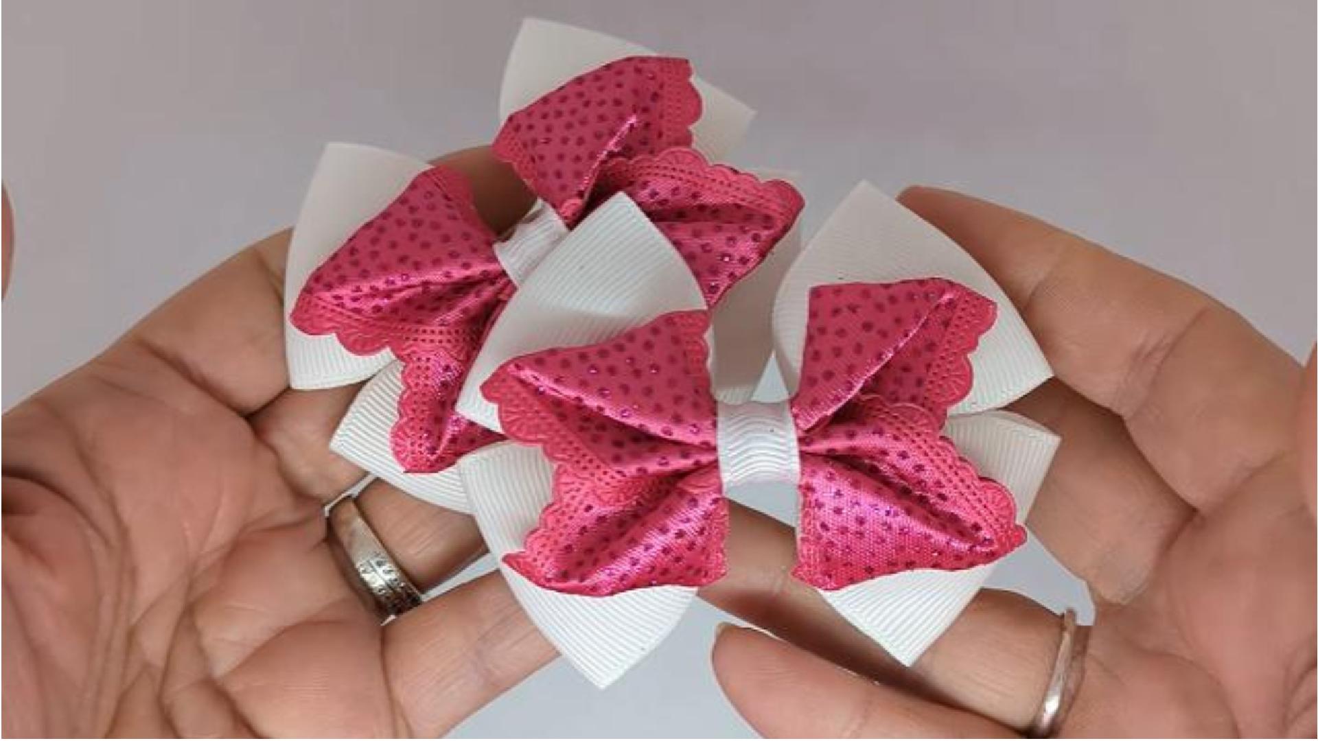 Close-up of white and cerise pink glitter hair bows on alligator clips, measuring 8cm x 6cm, showcasing the sparkle and colour contrast of the glitter and grosgrain ribbon.