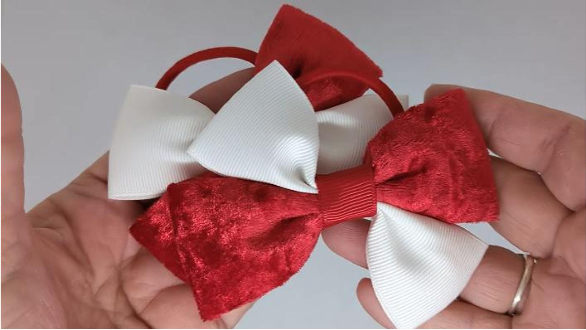 Close-up of red and white velvet hair bows on thick bobbles, measuring 10cm x 7cm, showcasing the soft velvet fabric and grosgrain ribbon combination.