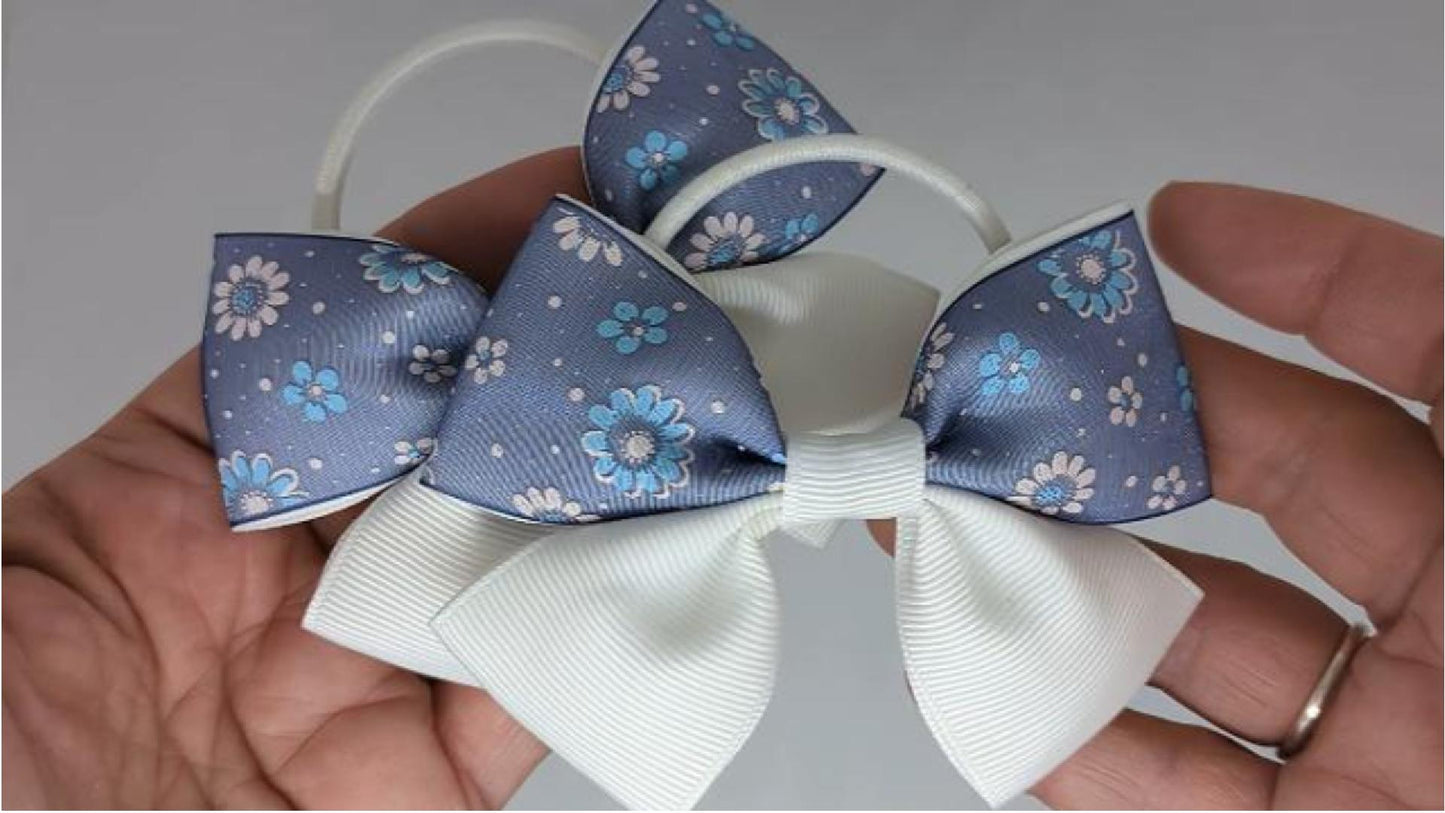 Close-up of white and navy blue floral hair bows on thick bobbles, measuring 10cm x 7cm, showcasing the detailed floral pattern on the organza ribbon.