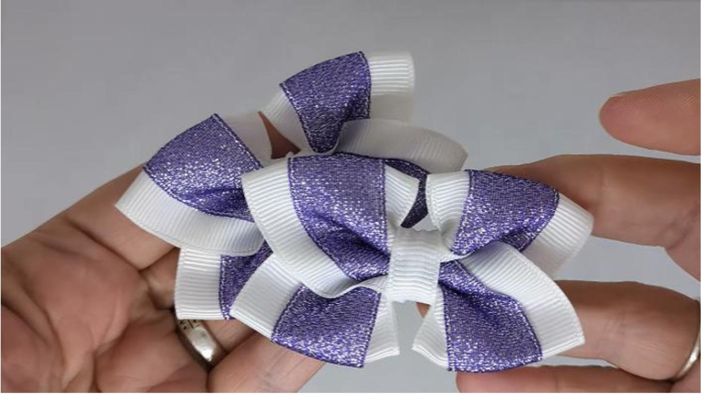 Close-up of white and purple glitter hair bows on alligator clips, measuring 7cm x 5cm, showcasing the sparkle of the glitter ribbon.