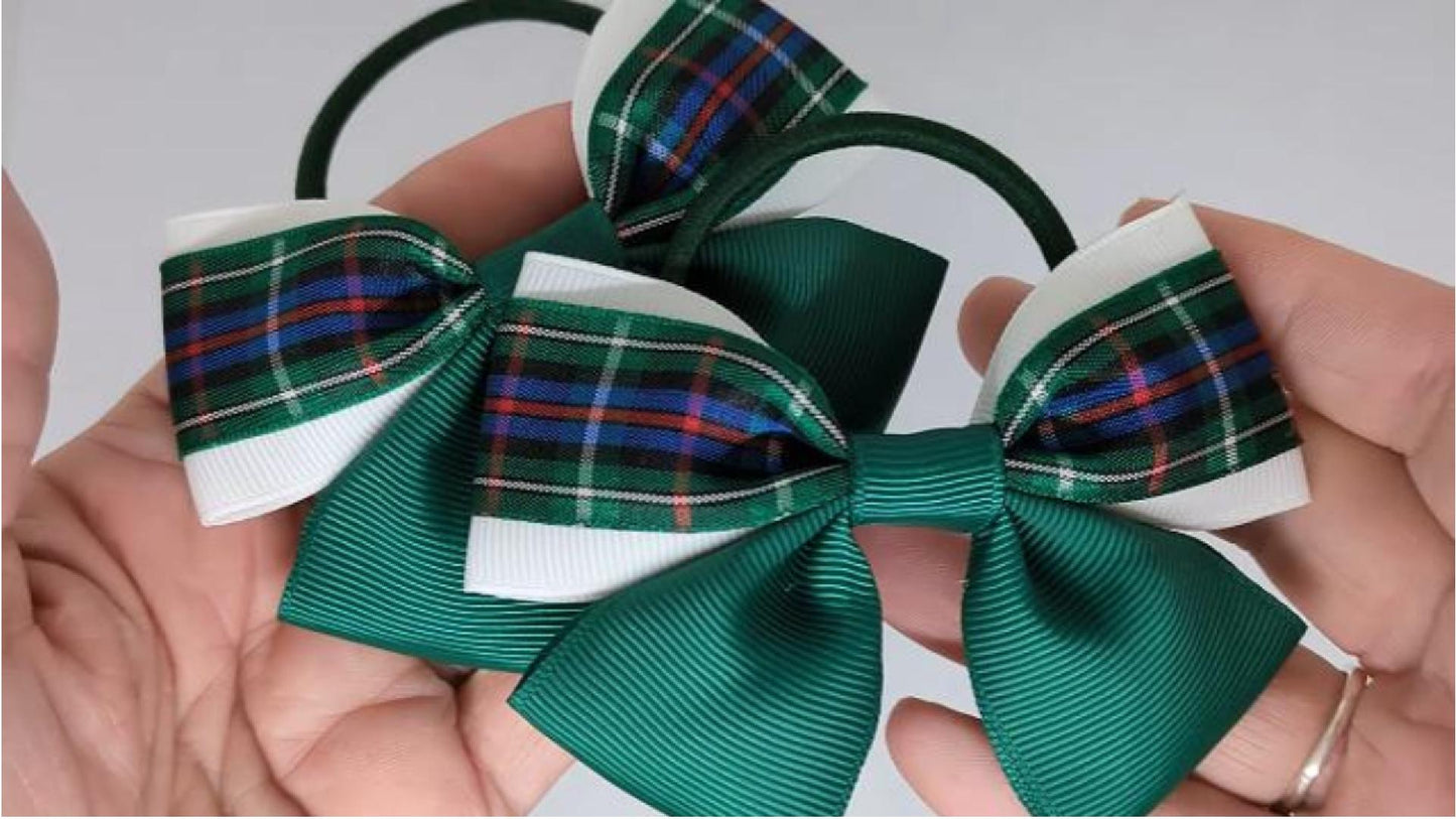 Close-up of bottle green Rose tartan hair bows on thick bobbles, measuring 10cm x 7cm, showcasing the combination of grosgrain and tartan ribbon.