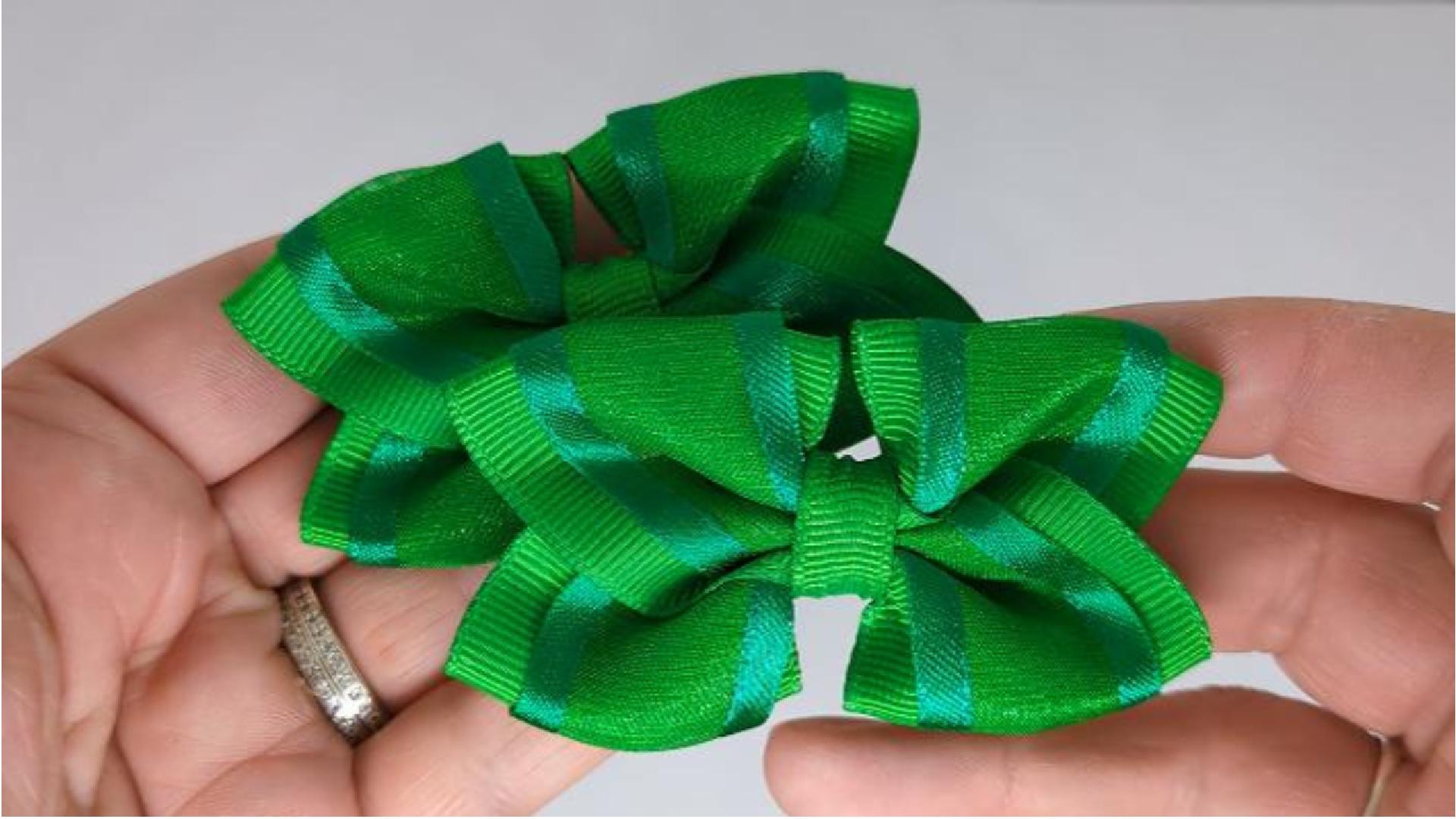 Close-up of emerald green organza hair bows on alligator clips, measuring 7cm x 5cm, showcasing the soft combination of organza and grosgrain ribbon.